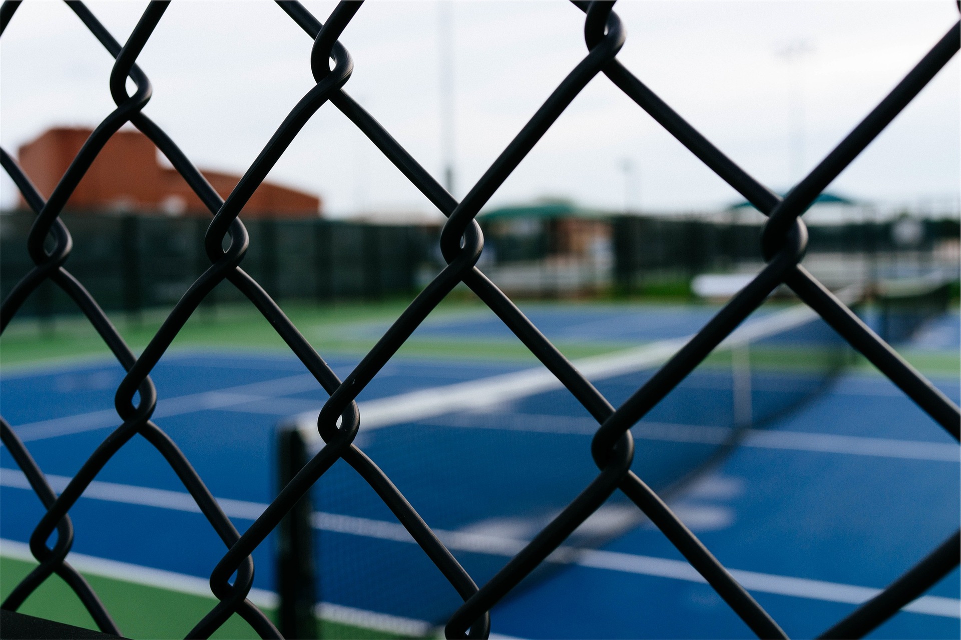 Tennis court seen through the fence